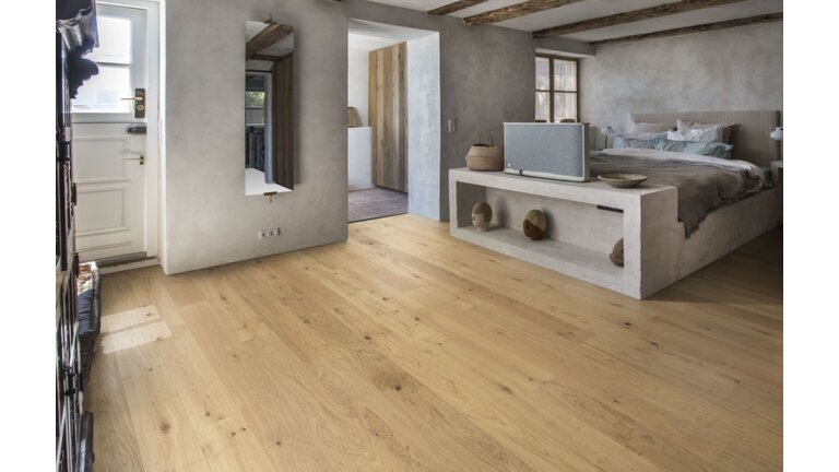 Rustikales Schlafzimmer mit hellen Holzdielen.